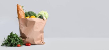 Gri arka planda taze sebzeli kağıt alışveriş torbası.