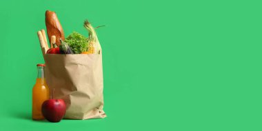Yeşil zemin üzerinde farklı taze ürünlere sahip kağıt alışveriş torbası ve metin için boşluk