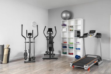 Raf ünitesi ve spor ekipmanlarıyla birlikte spor salonu.