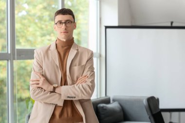 Portrait of handsome businessman near window in conference hall