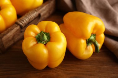 Ahşap arka planda sarı dolma biber, yakın plan.