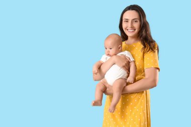 Beautiful young happy mother with her cute little baby on blue background