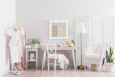 Makyaj odasının içinde makyaj masası, ayna ve katlanır ekran var.