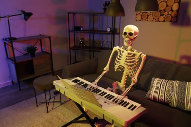 Human skeleton model with synthesizer in dark living room