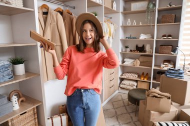 Young woman with wardrobe boxes in dressing room