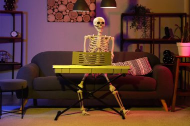 Human skeleton model with synthesizer in dark living room