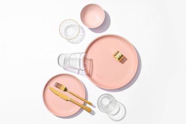 Gri arka planda altın çatal bıçak ve gözlüklerle güzel bir masa.