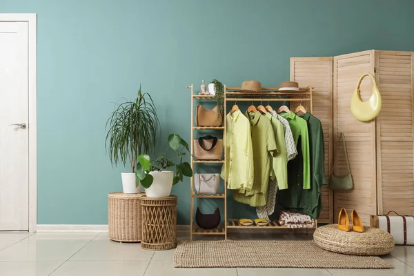 Giysi askısı, katlama perdesi ve bitkileri olan soyunma odasının içinde.