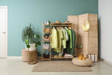 Giysi askısı, katlama perdesi ve bitkileri olan soyunma odasının içinde.