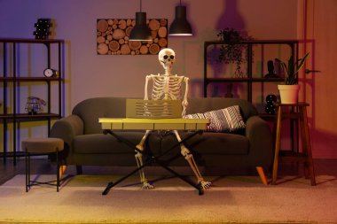 Human skeleton model with synthesizer in dark living room