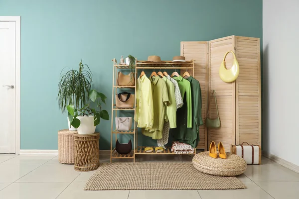 Giysi askısı, katlama perdesi ve bitkileri olan soyunma odasının içinde.