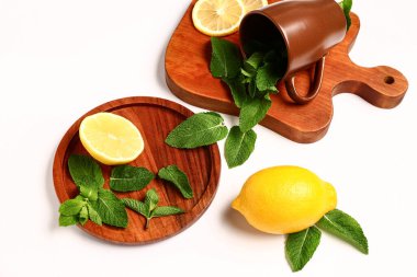 Bardaklı kompozisyon, taze nane ve beyaz arka planda limon.