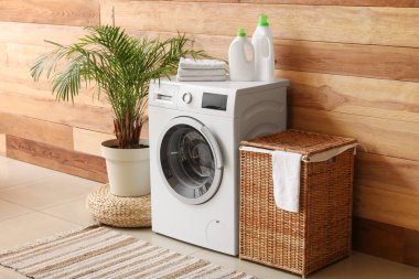 Çamaşır makinesi, el bilgisayarı ve çamaşır sepetinin olduğu odanın içi.