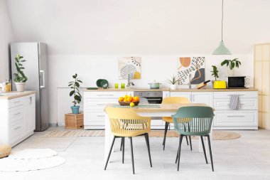 Masada turunçgiller olan beyaz mutfağın içi.