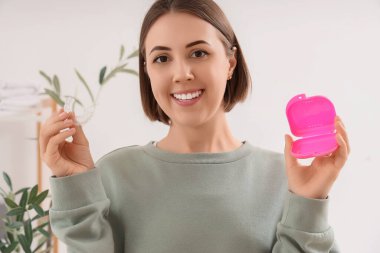 Young woman taking occlusal splint from box in bathroom, closeup