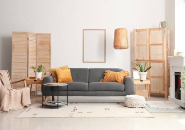 Cozy interior of living room with fireplace, sofa and folding screens