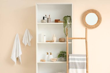 Banyo, raf ünitesi, merdiven ve bitkilerle dolu.