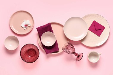 Zarflı ve pembe arka planda orkide çiçekli güzel bir masa.