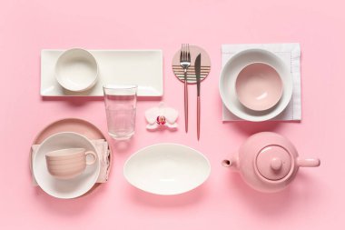 Gümüş çatal bıçak takımı ve pembe arka planda orkide çiçeğiyle güzel bir masa.