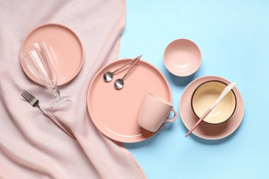 Mavi arka planda gümüş çatal bıçak seti olan güzel bir masa.