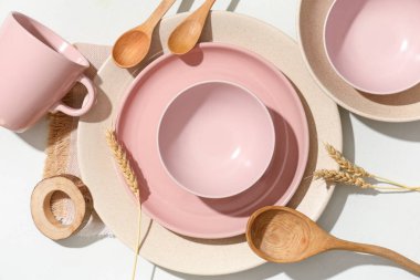 Ahşap kaşıklar ve beyaz arka planda buğday dikenleri olan güzel bir masa.