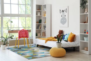 Interior of children's room with bed, study table and bookshelves