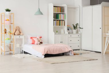 Interior of light children's room with bookshelf, bed and toys