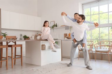 Mutlu baba, çocuklarıyla mutfakta eğleniyor.