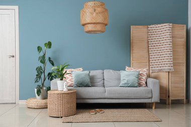 Interior of living room with sofa, plants and hanging lamp