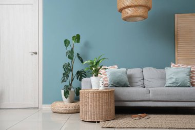 Interior of living room with sofa, plants and hanging lamp