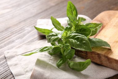 Tahta kesme tahtası ahşap arka planda taze fesleğen yaprakları, yakın plan