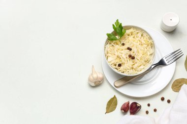 Lezzetli lahana turşulu kase ve beyaz arka planda farklı malzemeler.