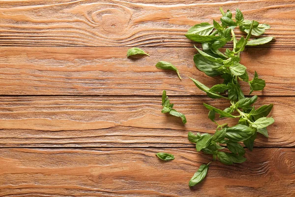 Tahta arka planda taze yeşil fesleğen yaprakları