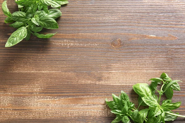 Tahta arka planda taze yeşil fesleğen yaprakları