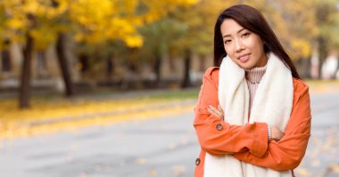 Sonbahar parkında güzel, mutlu, Asyalı bir kadın.