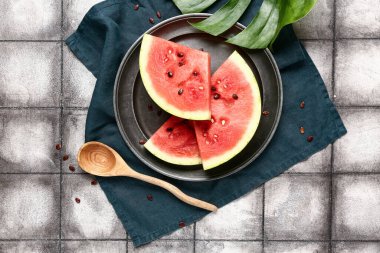 Taze karpuz parçaları ve gri fayanslı tohumlarla kaplı bir tabak.
