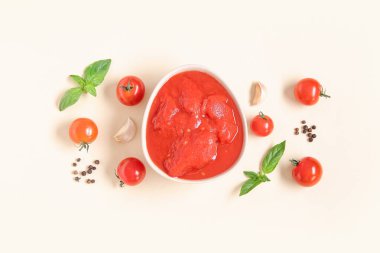 Renkli arkaplanda bir kase lezzetli domates ve baharatla kompozisyon.