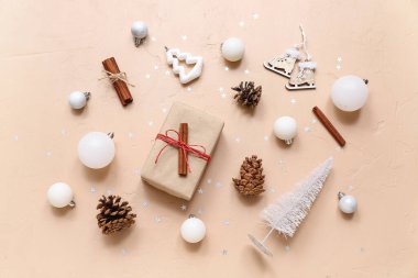 Bej arka planda farklı Noel süslemeleri ve hediye kutusu