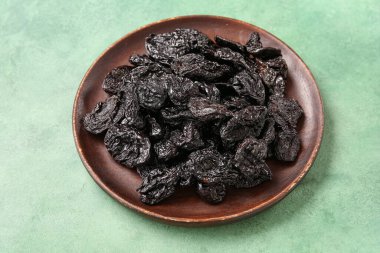 Yeşil arka planda lezzetli kurutulmuş erikli tabak.