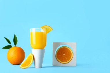 Mavi arka planda bir bardak taze portakal suyu ile dekoratif podyum