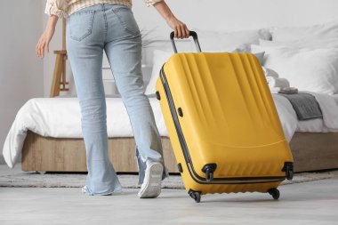 Bavullu kadın otel odasında, arka manzaralı.