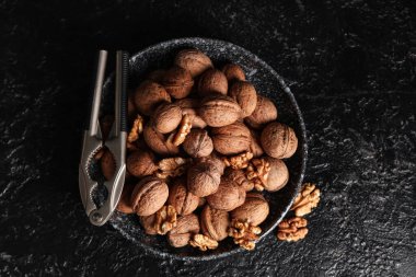 Lezzetli cevizli kase ve siyah arka planda fındıkkıran