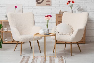 Koltuklar ve güzel Gerbera çiçekleri oturma odasının içinde.