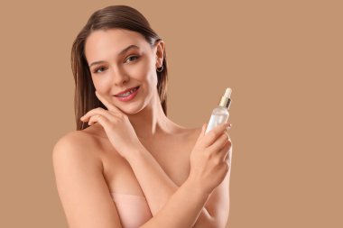 Diş telleri ve bej arka planda serumu olan genç bir kadın, yakın plan.