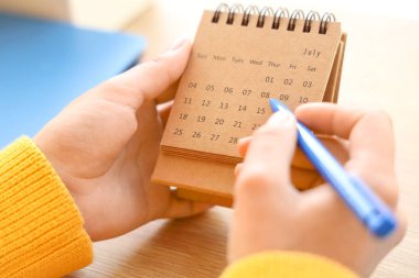 Masadaki takvimde kadın eli işaretleme günü, yakın plan