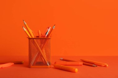 Turuncu masada kalemli kupa.