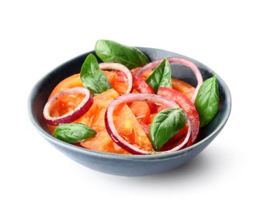 Beyaz arka planda kırmızı soğan ve fesleğen yapraklı taze domates salatası.