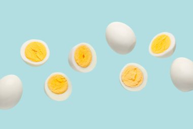 Mavi arka planda haşlanmış tavuk yumurtası.