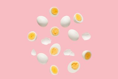 Pembe arka planda kabuklu haşlanmış tavuk yumurtası.