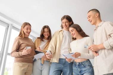 Group of students using mobile phones at university